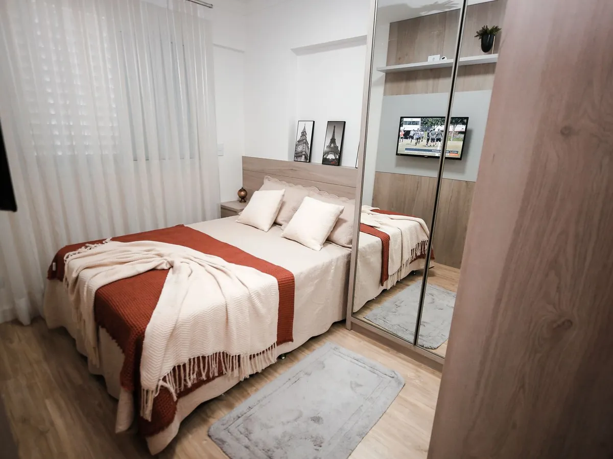 Quarto de casal com guarda-roupa de correr de portas espelhadas