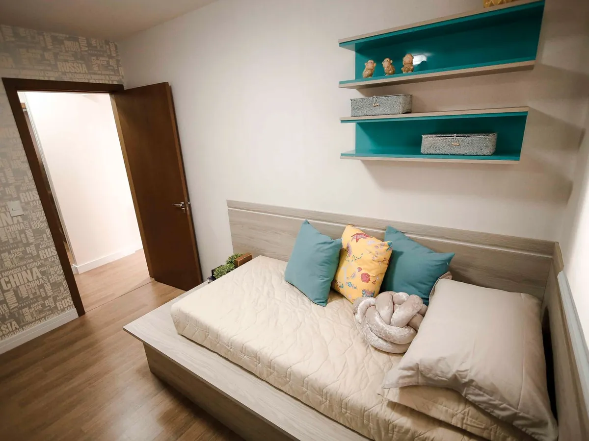 Quarto de solteiro com prateleiras coloridas e cabeceira planejada