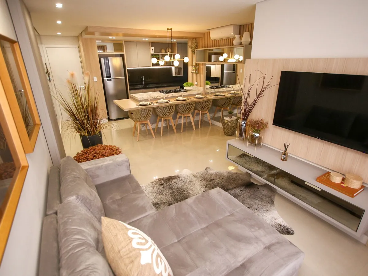 Sala com painel de TV e rack suspenso, integrada à cozinha planejada